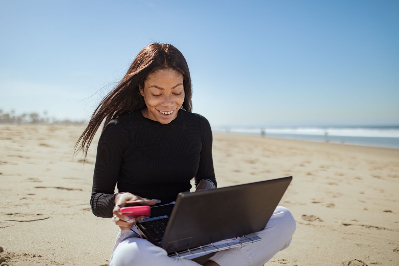 Donna lavora al computer portatile davanti al mare durante una consulenza a distanza
