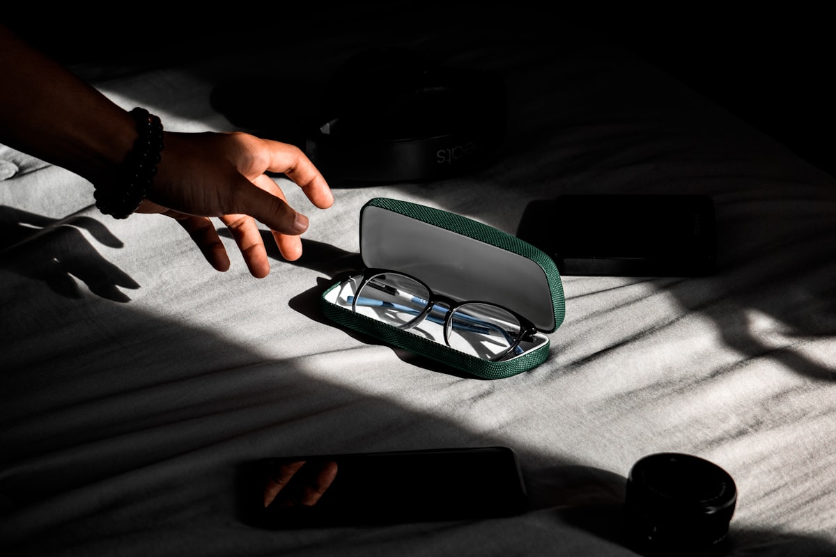 Occhiali da lettura in un astuccio su un tavolo, presi in mano