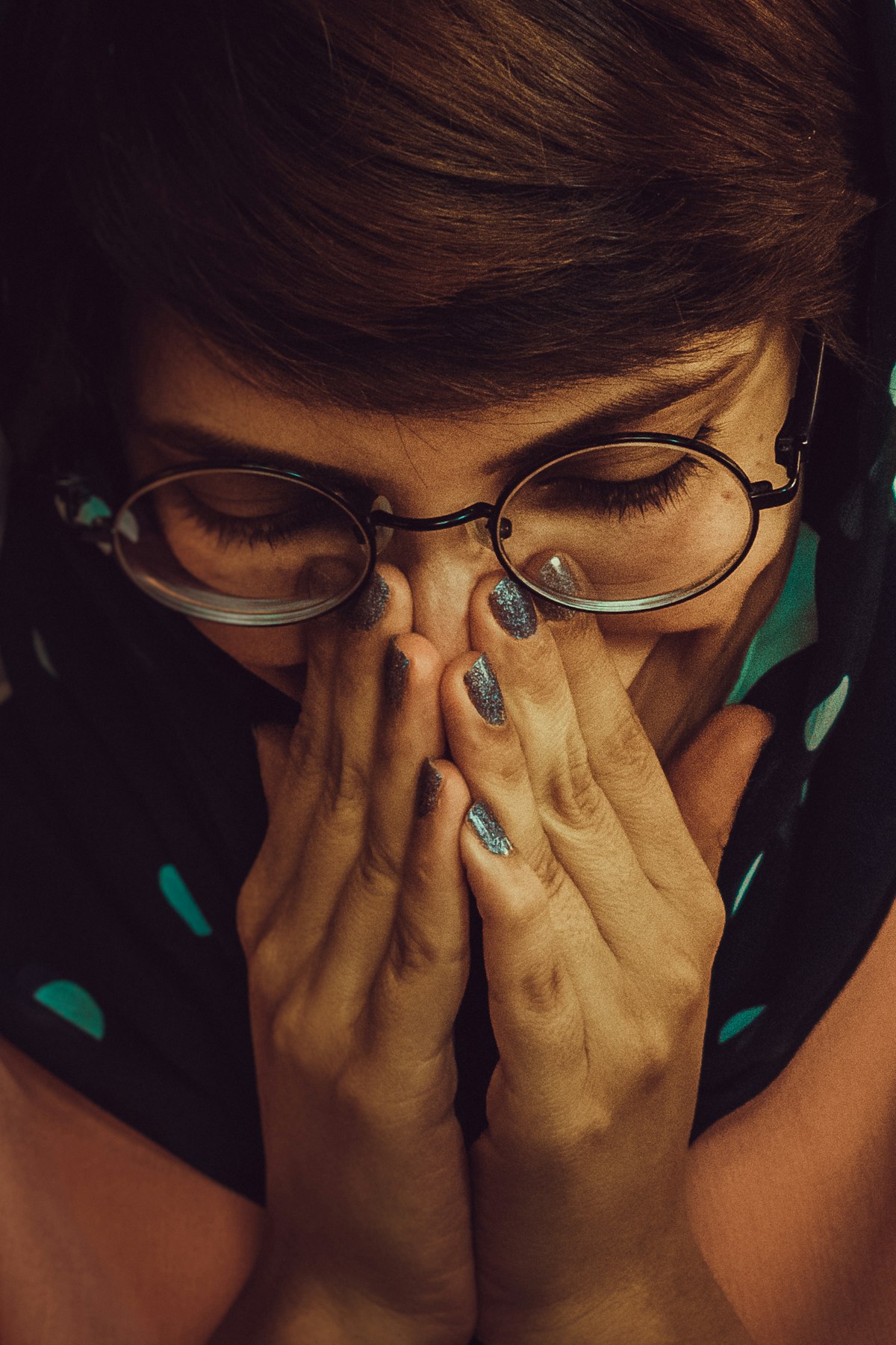 Donna con occhiali che si strofina gli occhi stanchi con le mani