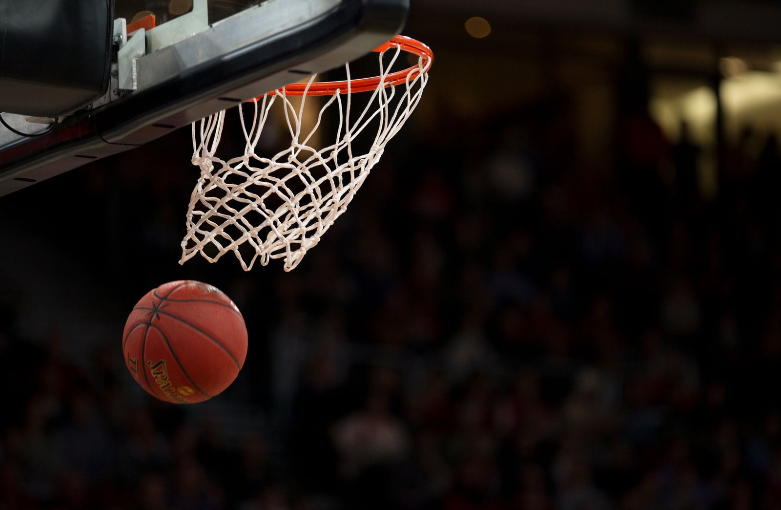 Pallone da basket in movimento verso il canestro durante una partita