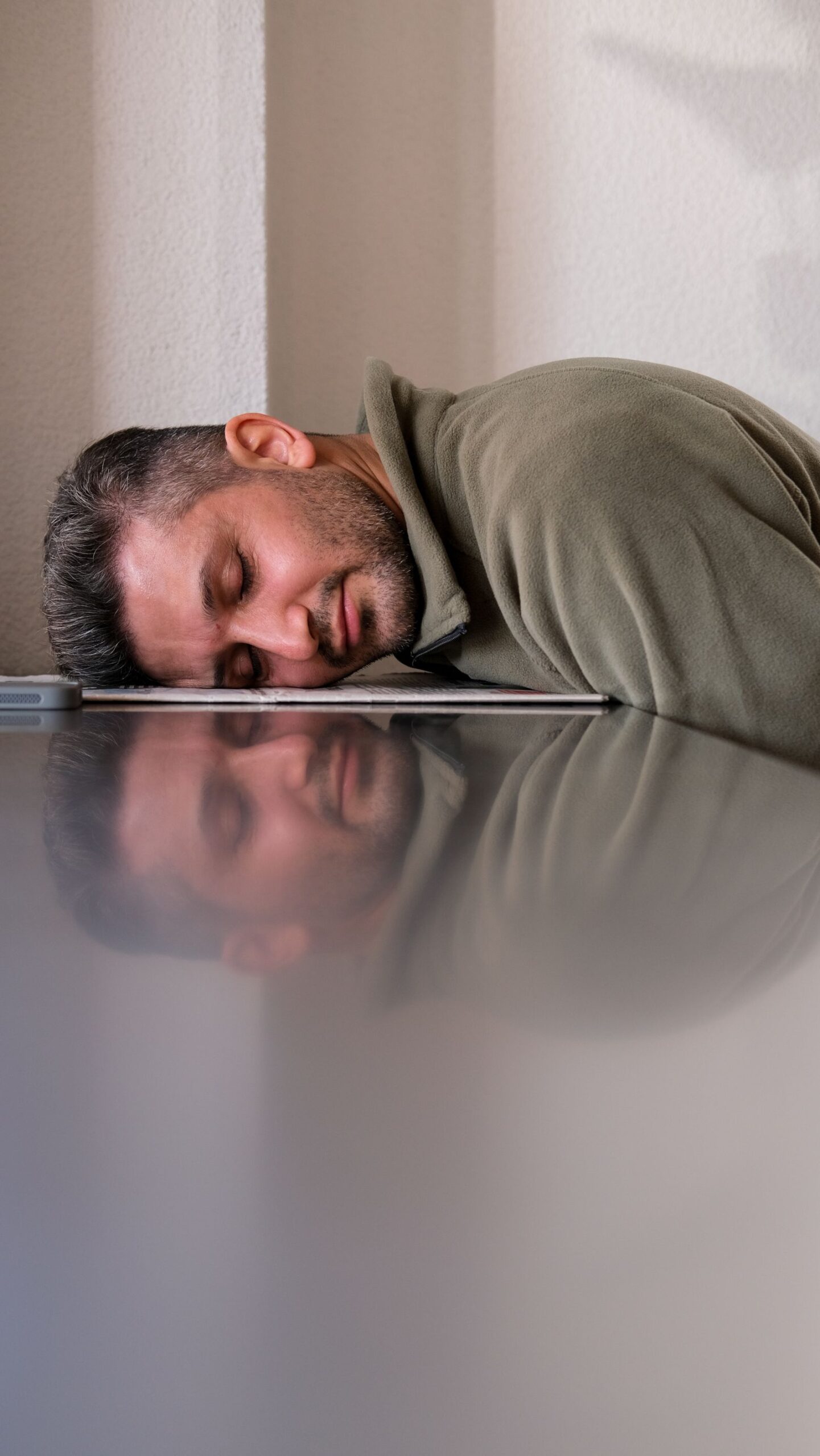 Uomo stanco appoggiato al portatile durante una giornata di lavoro