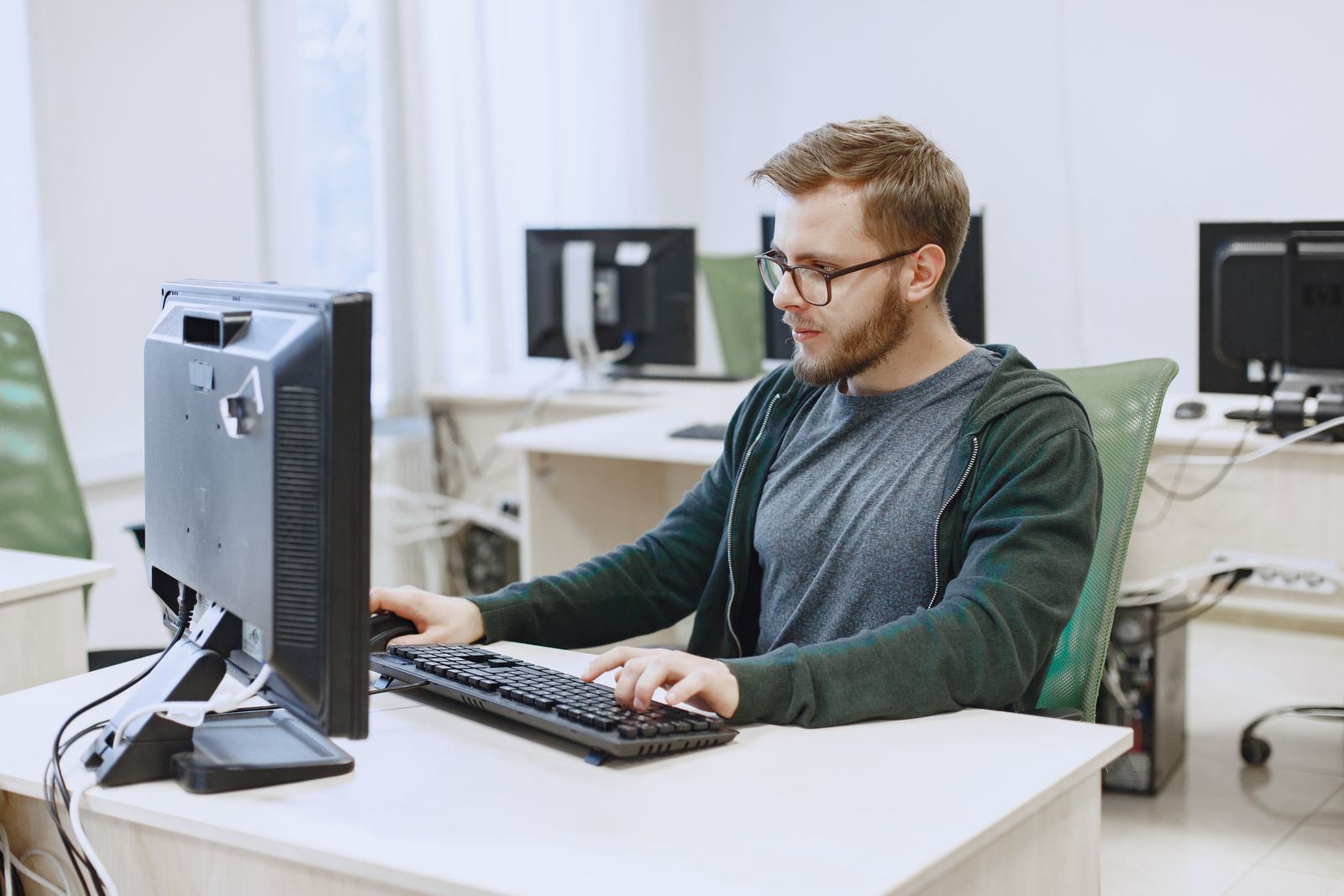 Professionista con occhiali lavora davanti a un monitor