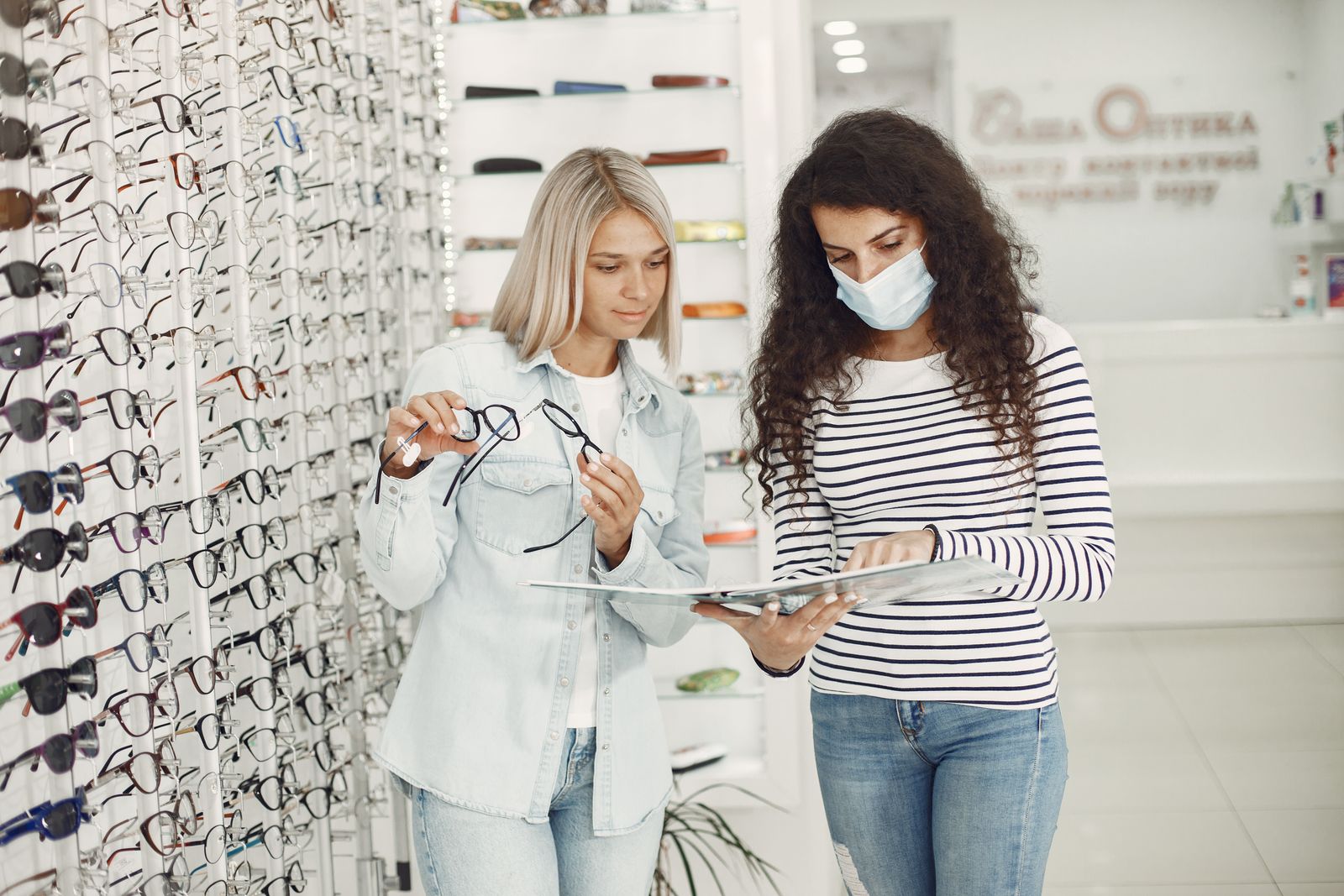 Professionista aiuta una cliente a scegliere e regolare una montatura da vista