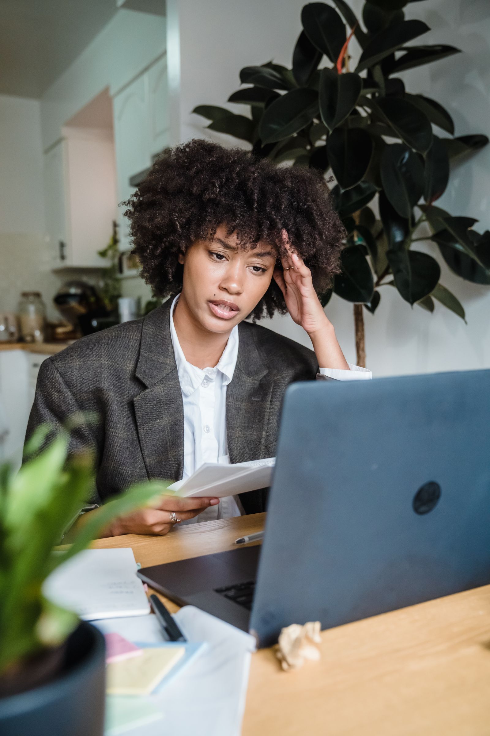 Lavoratrice in smart working affaticata davanti al portatile nella postazione di casa